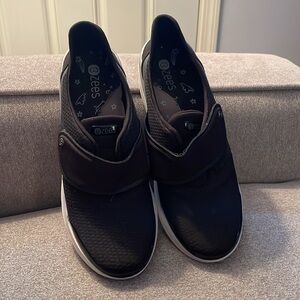 Bzees black slip ons with strap. Casual and comfortable. White soles